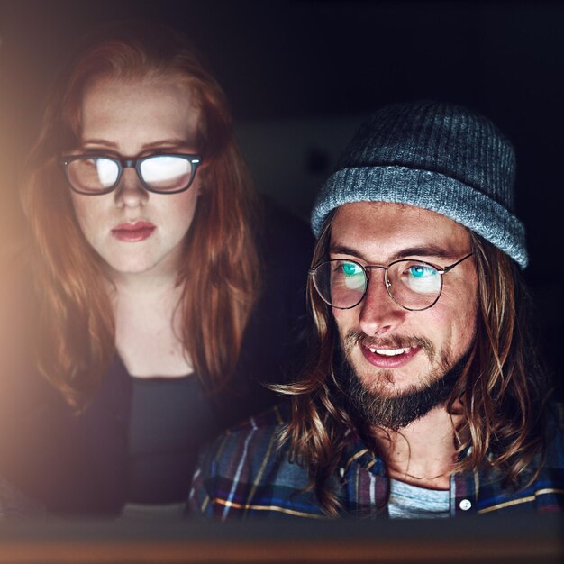 Startup business computer and people reading web design code cloud computing software or app UI system Website SEO social media content review or face of night team collaboration on UX interface