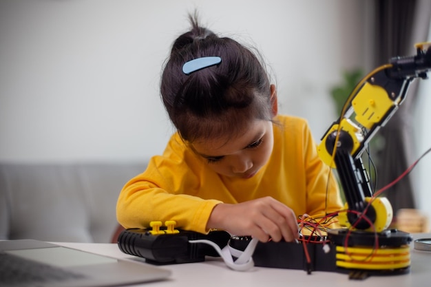 STEM education concept Asian students learn at home by coding robot arms in STEM mathematics engineering science technology computer code in robotics for kids concepts