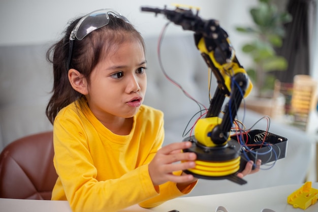 STEM education concept Asian students learn at home by coding robot arms in STEM mathematics engineering science technology computer code in robotics for kids' concepts