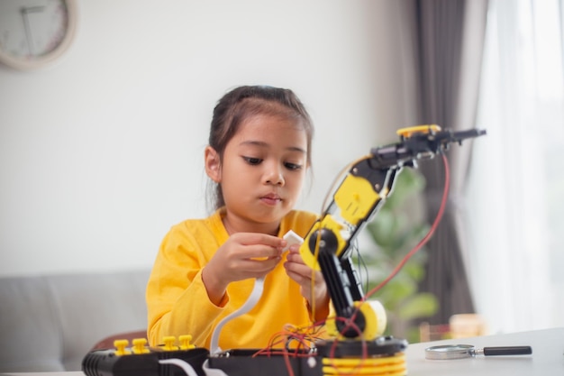 STEM education concept Asian students learn at home by coding robot arms in STEM mathematics engineering science technology computer code in robotics for kids' concepts