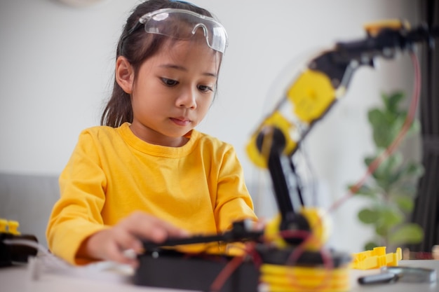 STEM education concept Asian students learn at home by coding robot arms in STEM mathematics engineering science technology computer code in robotics for kids' concepts