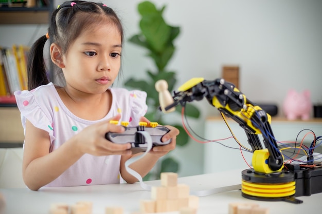 STEM education concept Asian students learn at home by coding robot arms in STEM mathematics engineering science technology computer code in robotics for kids' concepts
