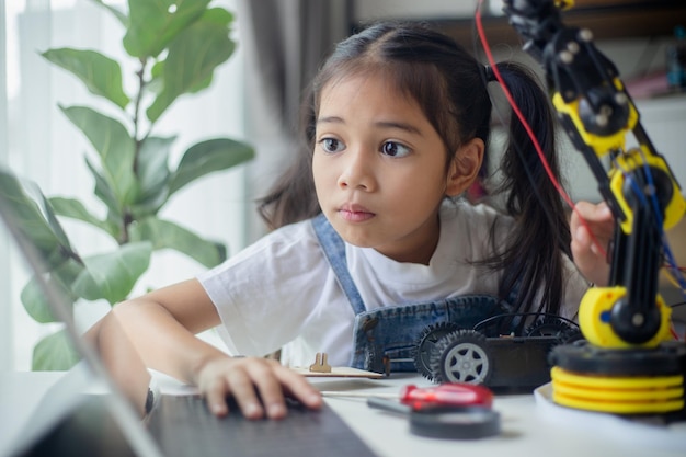 STEM education concept Asian young girl learning robot design