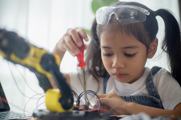 STEM education concept Asian young girl learning robot design