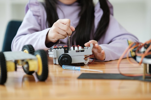 STEM education concept Asian young girl learning robot design