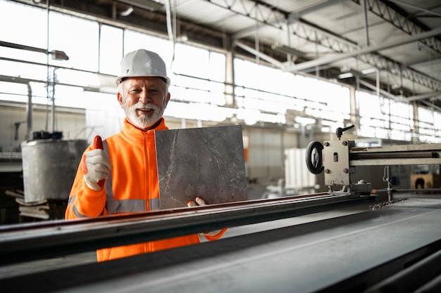 Successful ceramic tile production and factory worker checking quality color and texture.