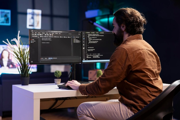system engineer in living room writing lines of code on computer