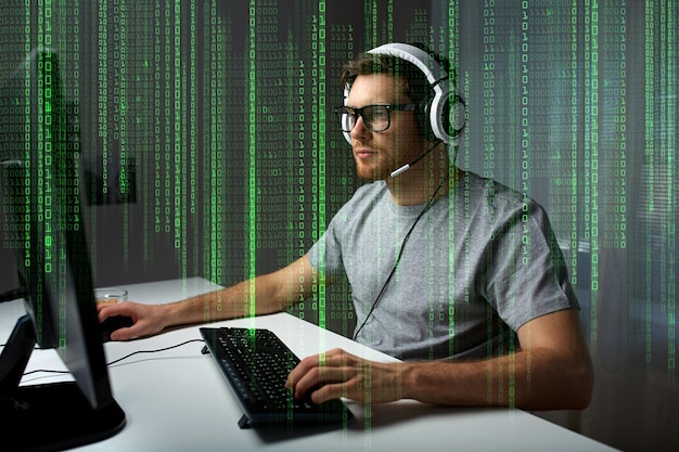 technology, gaming, entertainment, let&amp;#39;s play and people concept - young man in headset and glasses with pc computer playing game at home and streaming playthrough or walkthrough video