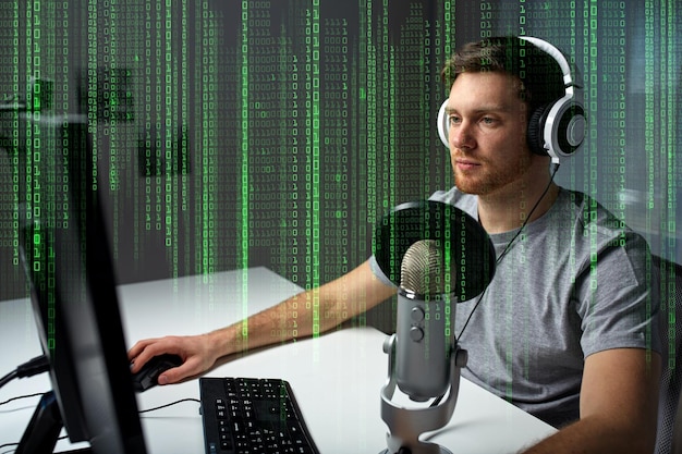technology, gaming, entertainment, let&amp;#39;s play and people concept - young man in headset with pc computer playing game at home and streaming playthrough or walkthrough video