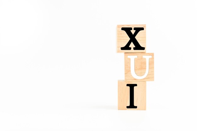 The Wooden cube on a white table with text UX UI Concept of development and design and development user interface user experience software app Copy space on left for design White background