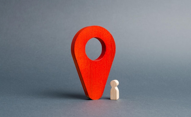 The wooden figurine of the child stands near a huge red pointer tracking the location
