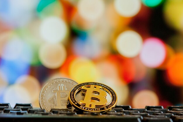 Tiền điện tử Bitcoin trên bàn phím máy tính trên nền bokeh