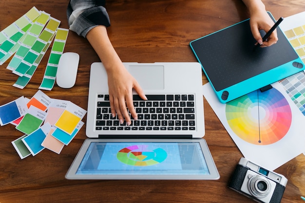 top view of graphic designer with graphic tablet and laptop