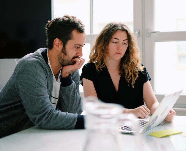 Two people looking at laptop in office meeting