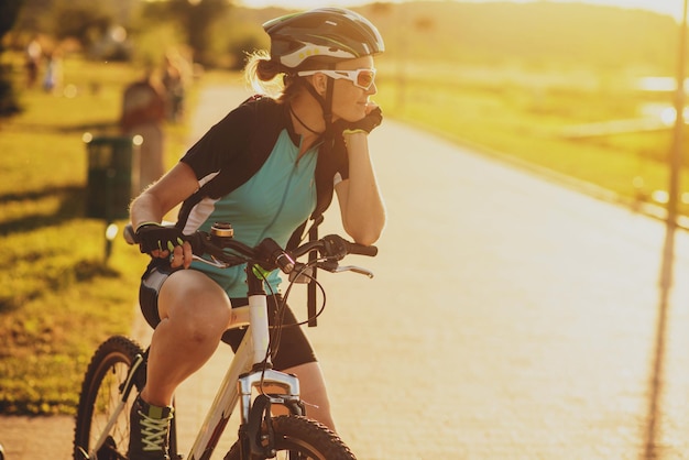 two women friends riding on bikes at the sunset