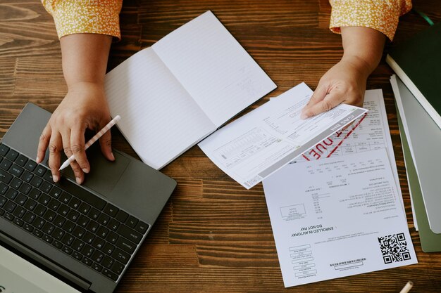 Unrecognizable woman looking through bills