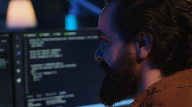 Upbeat teleworking IT professional in apartment writing lines of code close up