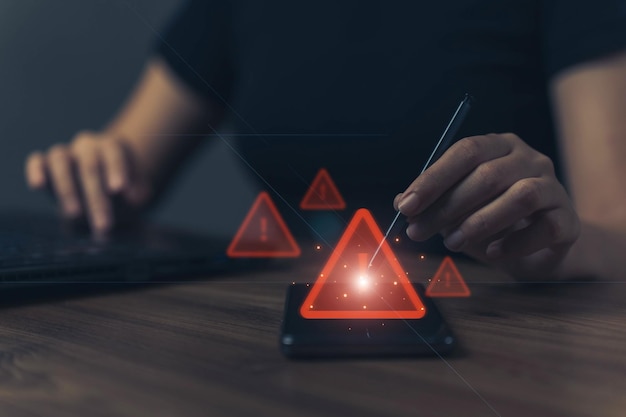 User is using mobile phone with triangle caution warning sign for notification error and maintenance concept hacker attacks and hacking data cyber crime cyber security
