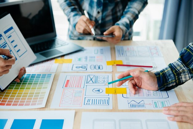 ux developer and ui designer brainstorming about mobile app interface wireframe design with customer breif and color code at modern officexa