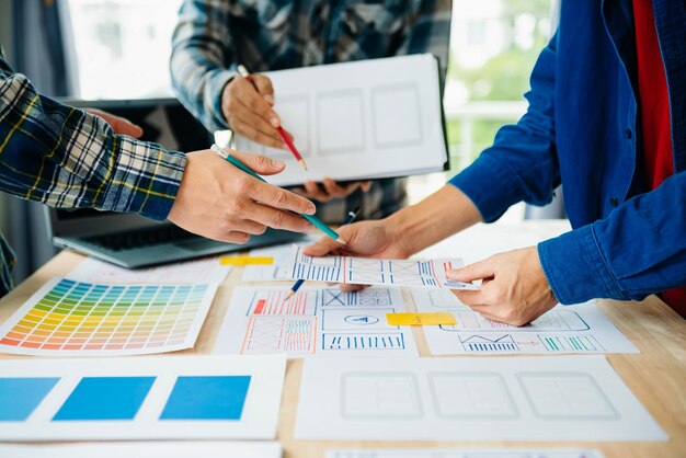 ux developer and ui designer brainstorming about mobile app interface wireframe design with customer breif and color code at modern officexa
