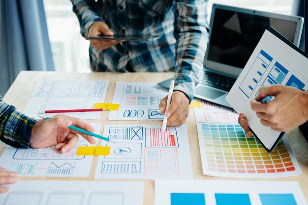 ux developer and ui designer brainstorming about mobile app interface wireframe design with customer breif and color code at modern officexa