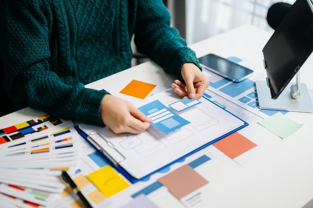 UX developer and ui designer brainstorming about mobile app interface wireframe design with customer breif and color code xA