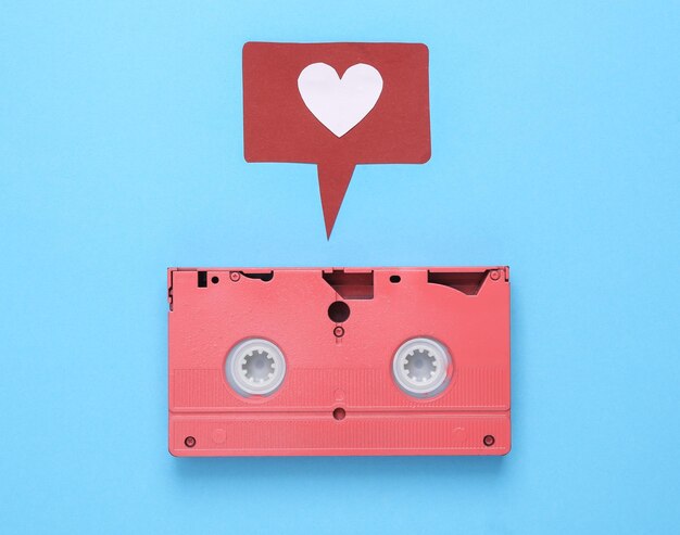 VHS video cassette with like notification icon on blue background Social media Rating followers feedback Top view