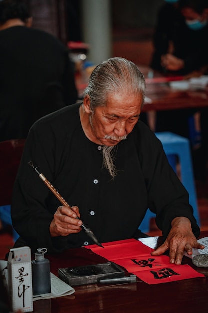 vietnamese scholar writes calligraphy at long son calligraphy festival is a popular tradition during tet holiday writing couplets for spring festival new year