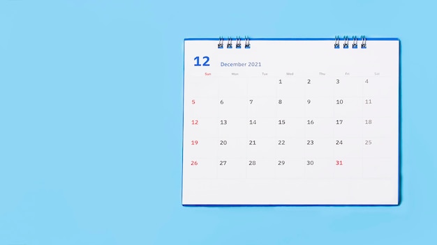 white desk calendar on blue background, planning concept