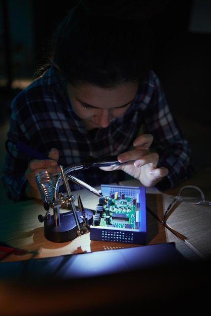 woman computer motherboard and night with soldering iron manufacturing and microchip for it development information technology circuit board and electronics for engineering hardware and system