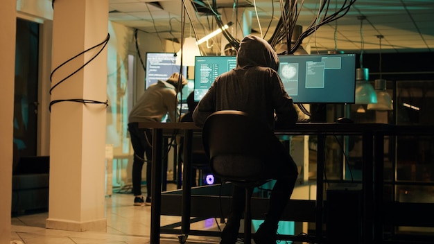 Woman hacker planning phishing and espionage at night, trying to break server firewall for cryptojacking or cyberbullying. Criminal hacking network system on computer, anonymous.
