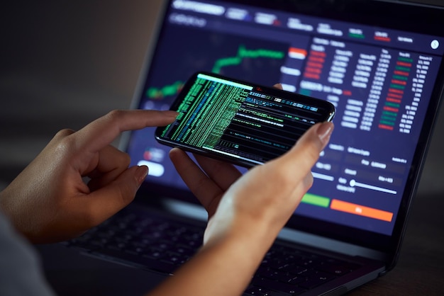 woman hands and phone on stock market for financial profit increase or coding at night by the office female person trader or broker on mobile smartphone in trading exchange or finance investment