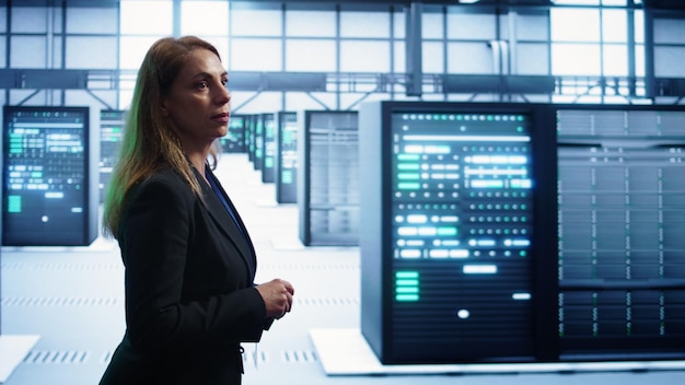 Woman in server hub establishment doing diagnosis looking for equipment bugs