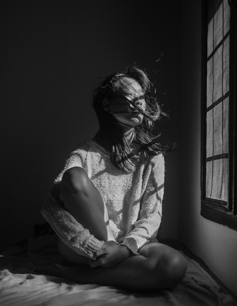 woman sitting by window at home