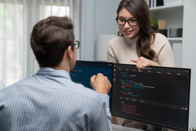 woman standing opposite to man programmer working on desk to discuss postulate