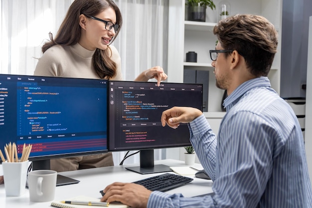 woman standing opposite to man programmer working on desk to discuss postulate