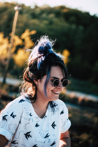 woman wearing sunglasses while standing against trees