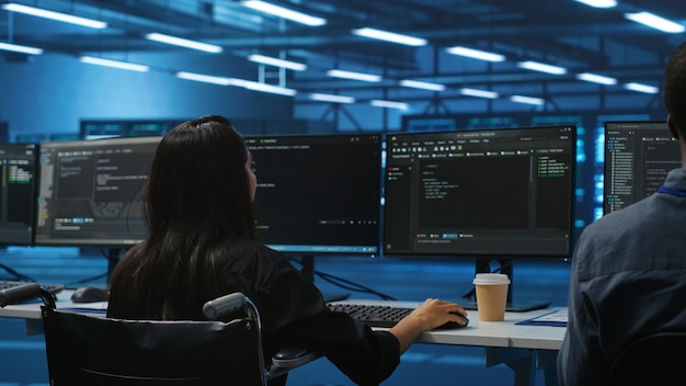 woman with impairment next to diverse coworkers in data center coding