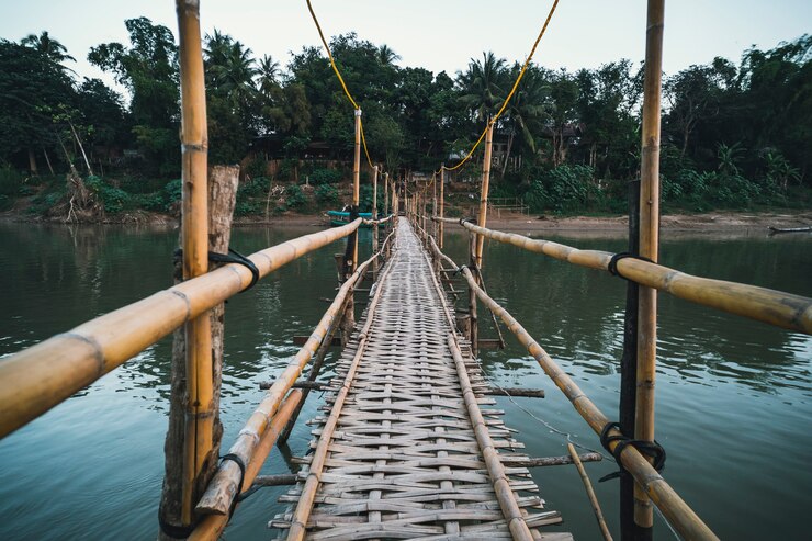 Photo wooden bridge over nam khan rive in luang prabang, laos. old dangerous bridge of bamboo. perspective view
