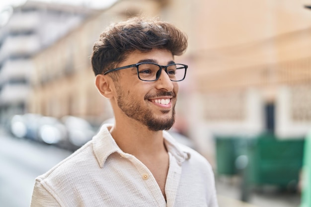 young arab man smiling confident wearing glasses at street