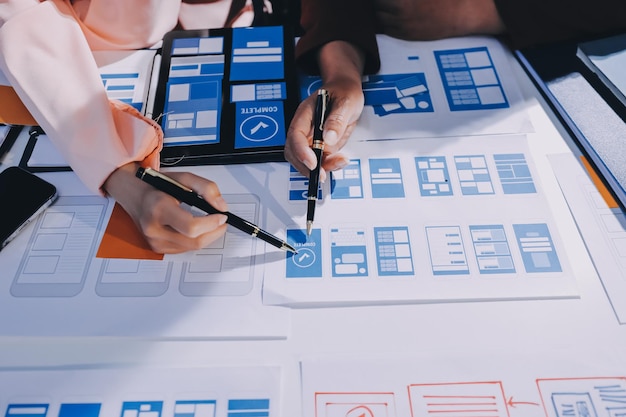 Young Asian business creative team work together mobile application software design project Brainstorm meeting internet technology smartphone web app designer office coworker teamwork concept