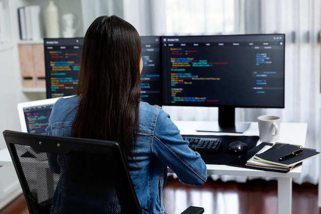 young asian in it creating with typing online information on pc stratagem