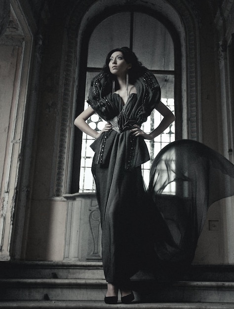young beautiful brunette woman standing in the palace room
