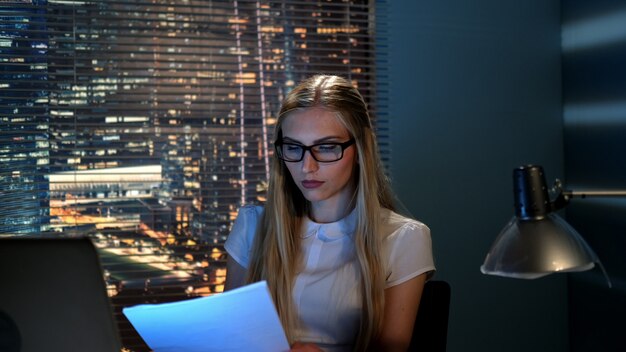 Young female economist checking the report and calling to the colleague for consultation