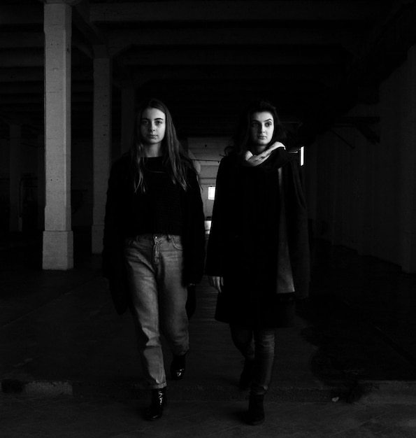 young female friends walking in corridor