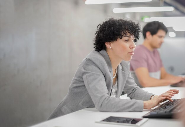 young female software developer using desktop computer while writing programming code at modern creative startup office