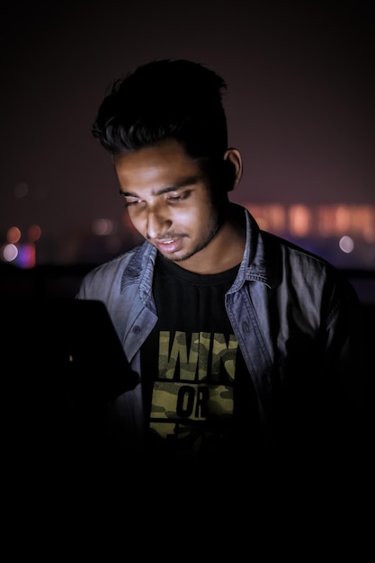 Young man using mobile phone at night
