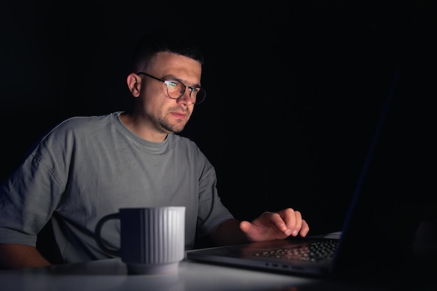 Young man works at the computer at night