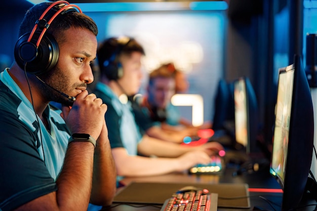 Young professional esports players playing online games in internet cafe