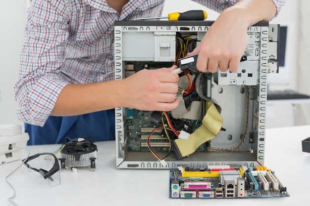 Young technician working on broken computer